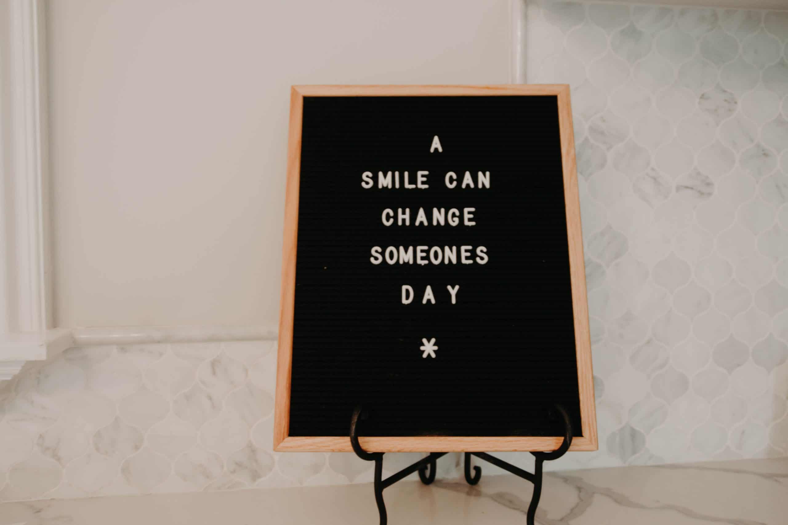 A smile can change someones day writing on a sign