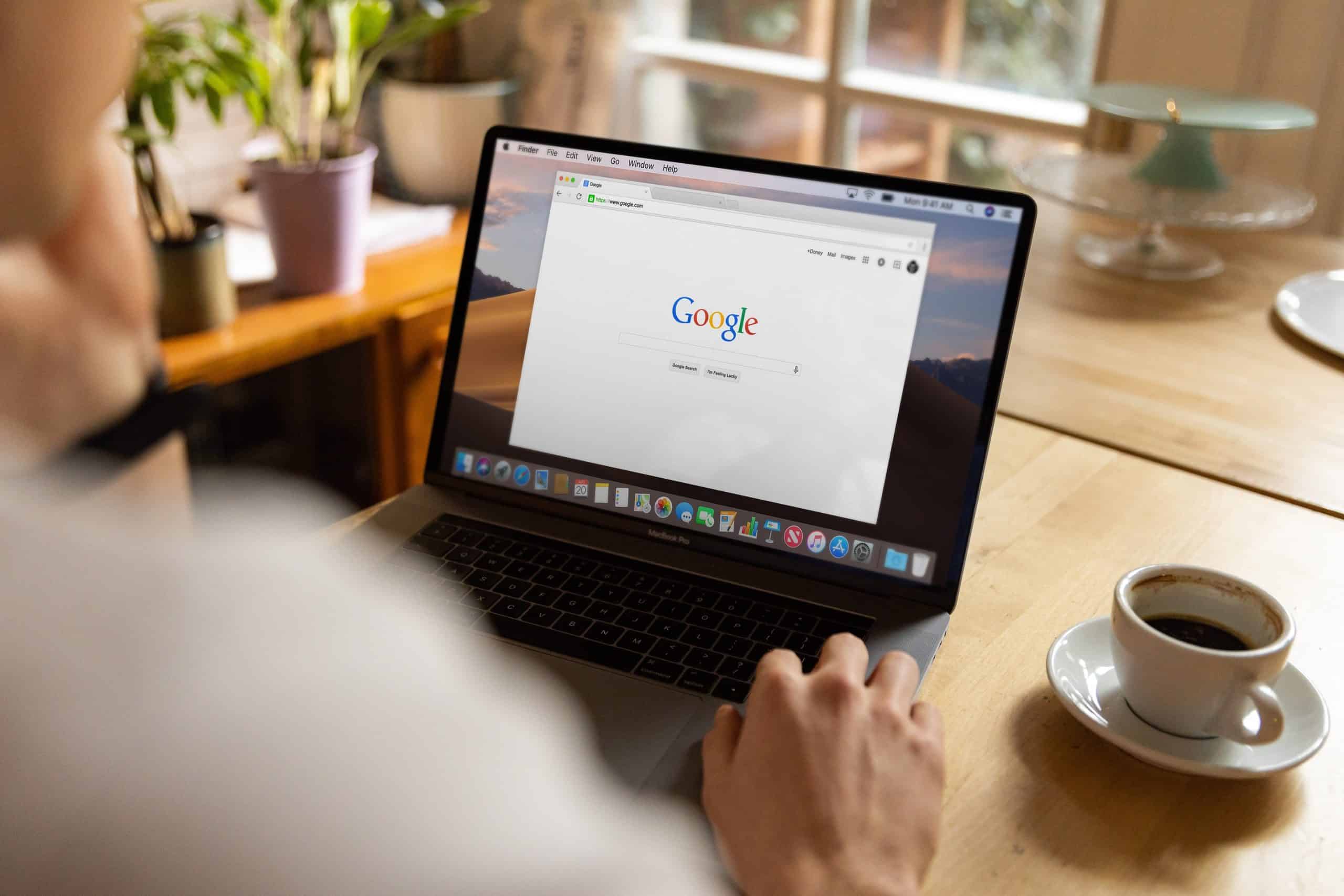 Hands on a laptop with google and coffee nearby-2