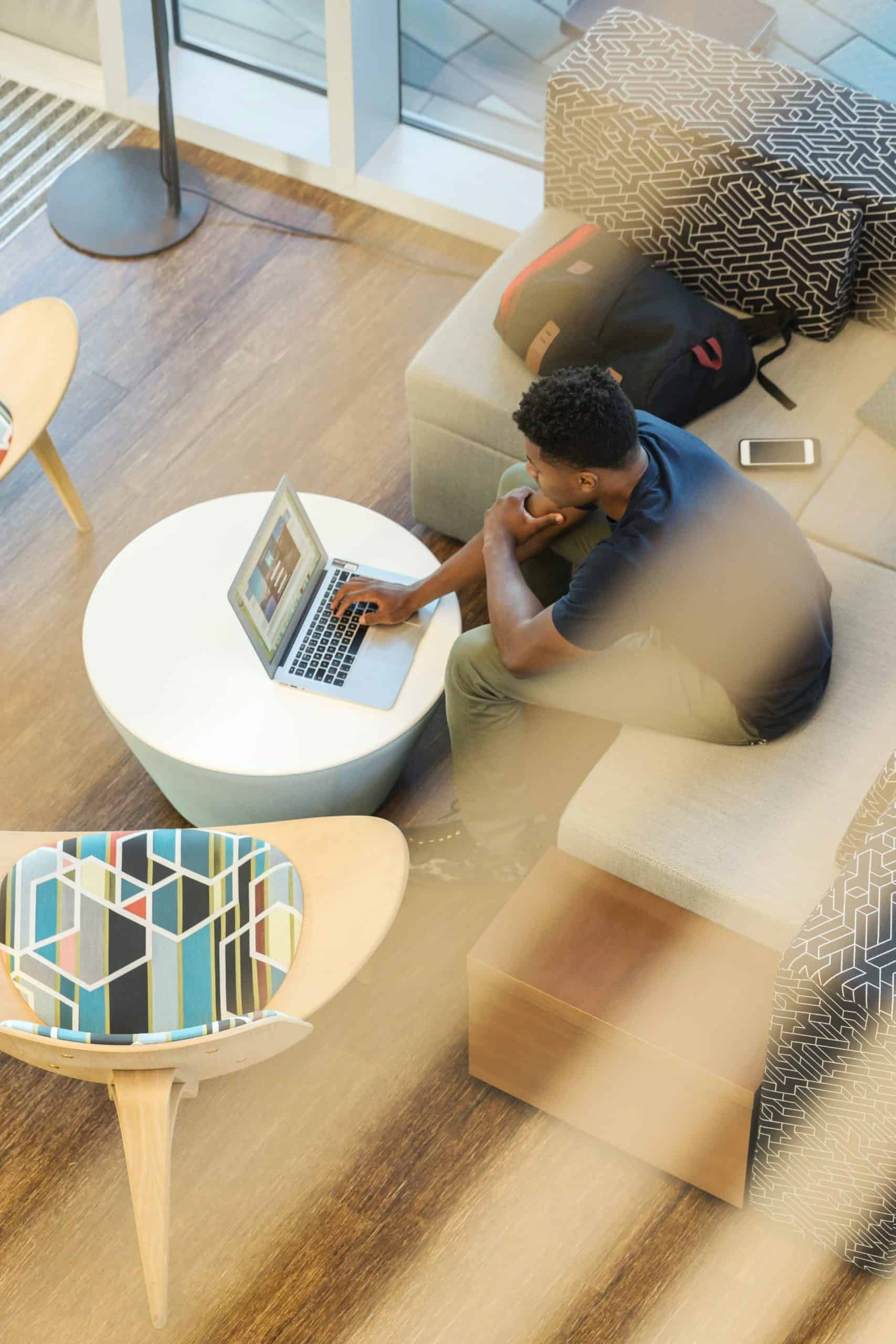 person working on laptop on couch in living room