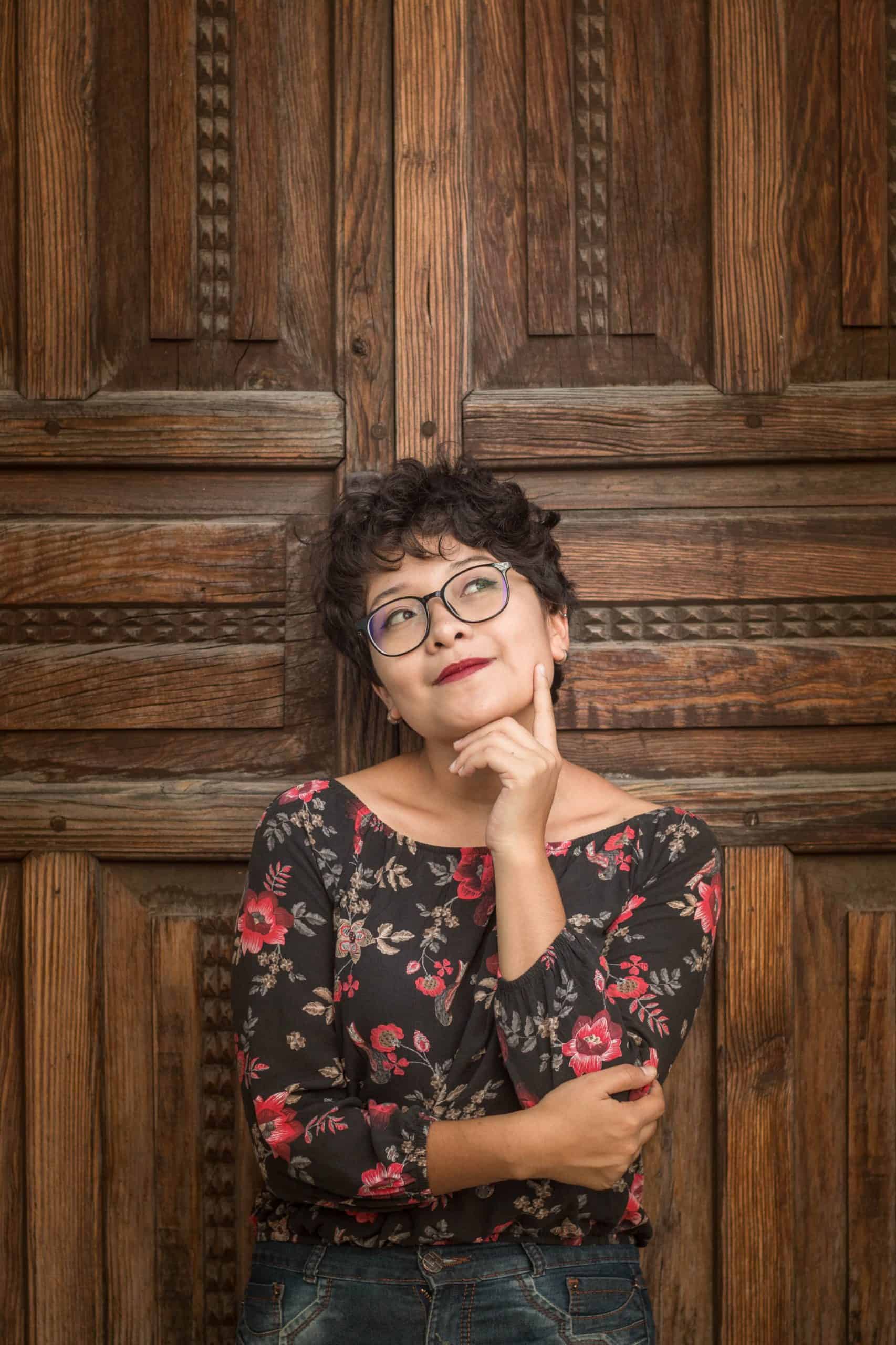 woman thinking against a wooden door